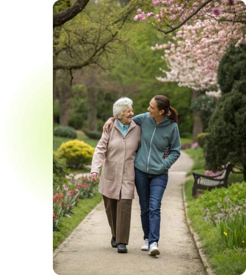 Seniorin genießt Spaziergang mit Altenpflegerin.