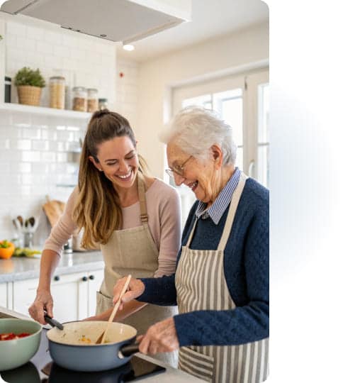 Seniorin mit Alltagshelfer beim gemeinsamen Kochen – Unterstützung im Haushalt für ältere Menschen.