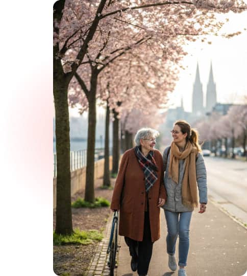 Ältere Frau mit Pflegekraft beim Spaziergang – professionelle Altenpflege.