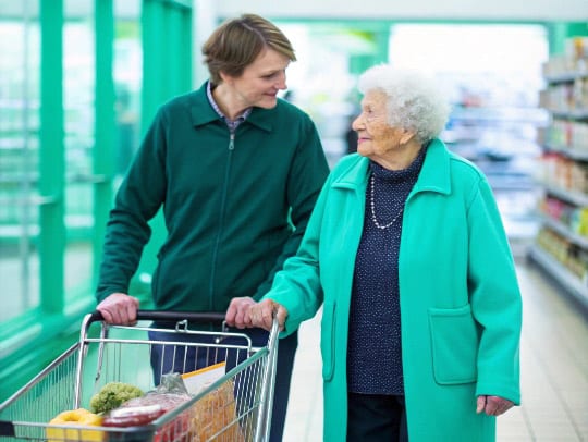 Eine Alltagsfee hilft einer Seniorin beim Einkauf in Herne.