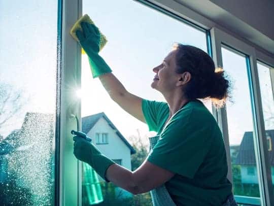 Eine Alltagsfee putzt sorgfältig ein Fenster in Gladbeck.