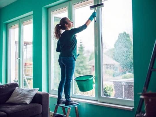 Eine freundliche Alltagsfee putzt ein Fenster in einem Haus in Unna.