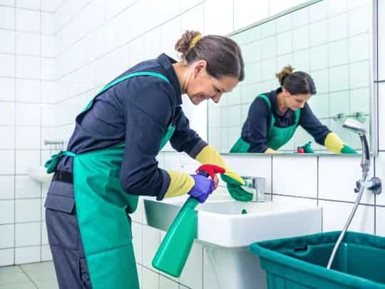 Professionelle Haushaltshilfe reinigt ein Badezimmer in Velbert.