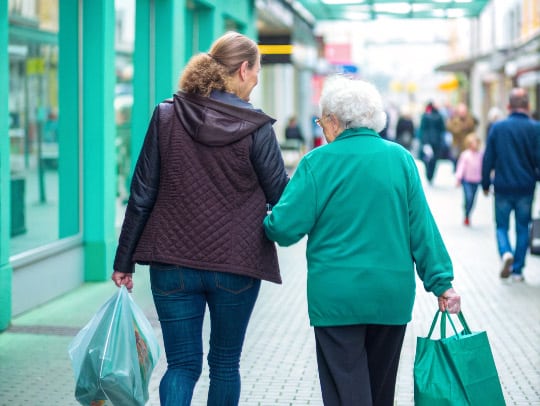 Eine Alltagsfee hilft einem Senior beim Einkaufen in Bornheim