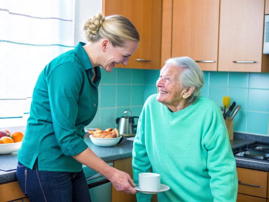· Eine Alltagsfee und eine Seniorin lächeln in einer Küche in Ibbenbüren