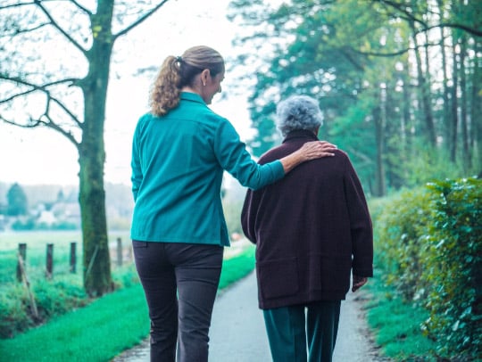 Eine Alltagsfee hilft einem Senior beim Spaziergang in Meerbusch