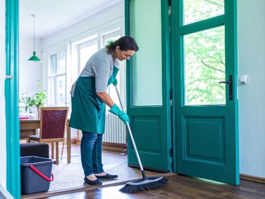 Eine freundliche Alltagsfee beim Reinigen in einem Haus in Menden